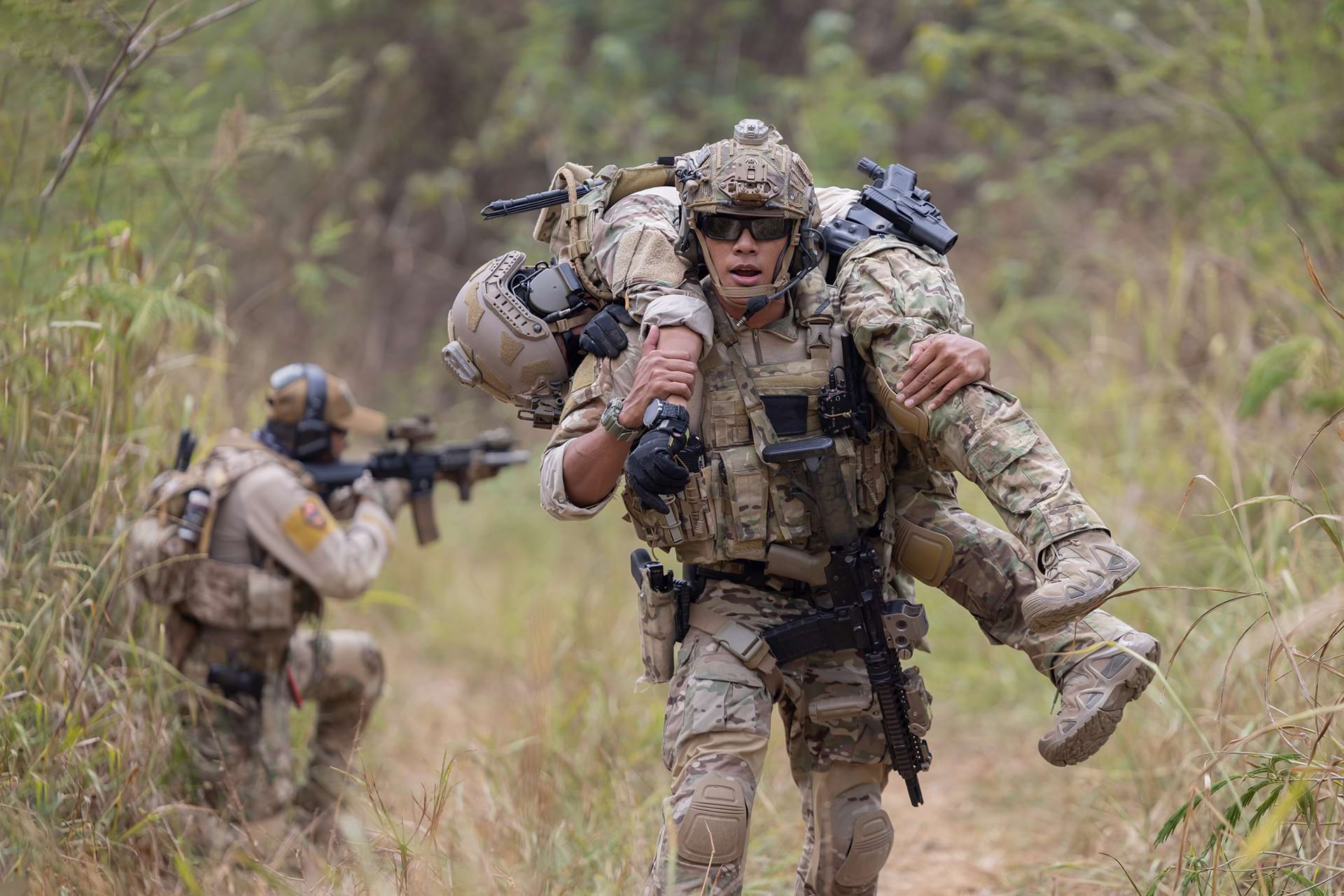 a soldier carries a wounded comrade